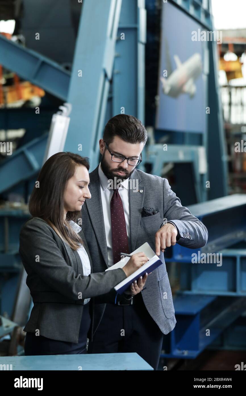 Portrait of a solid businessman with his secretary holding blue ...