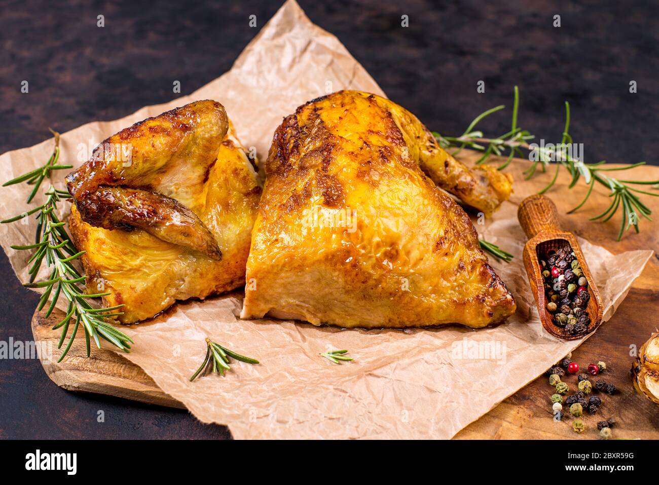 Grilled Chicken Half Of Baked Chicken On Food Paper On A Kitchen Wooden Board With Spices And Baked Garlic Close Up Stock Photo Alamy