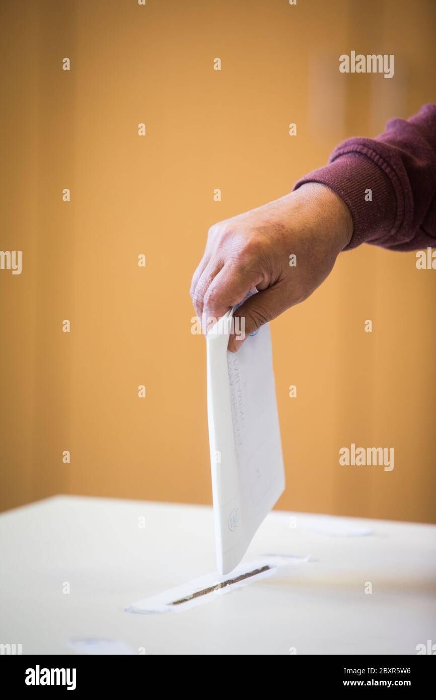 Polling Ballet Color image of a person casting a ballot at a polling station, during ...