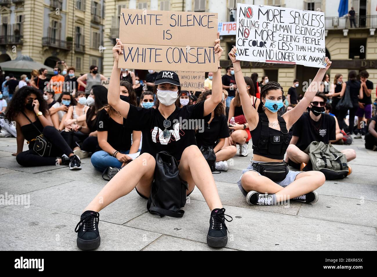 Turin, Italy - 06 June, 2020: Protesters hold placards reading 'White silence is white consent' and 'No more sensless killing of human Beings!! No more seeing people of color as less than human. We can no longer look away!!' during a demonstration calling for justice for George Floyd, who died May 25 after being restrained by police in Minneapolis, USA. People have protested peacefully in Turin to show solidarity with anti-racism movement Black Lives Matter in the U.S. and elsewhere. Credit: Nicolò Campo/Alamy Live News Stock Photo
