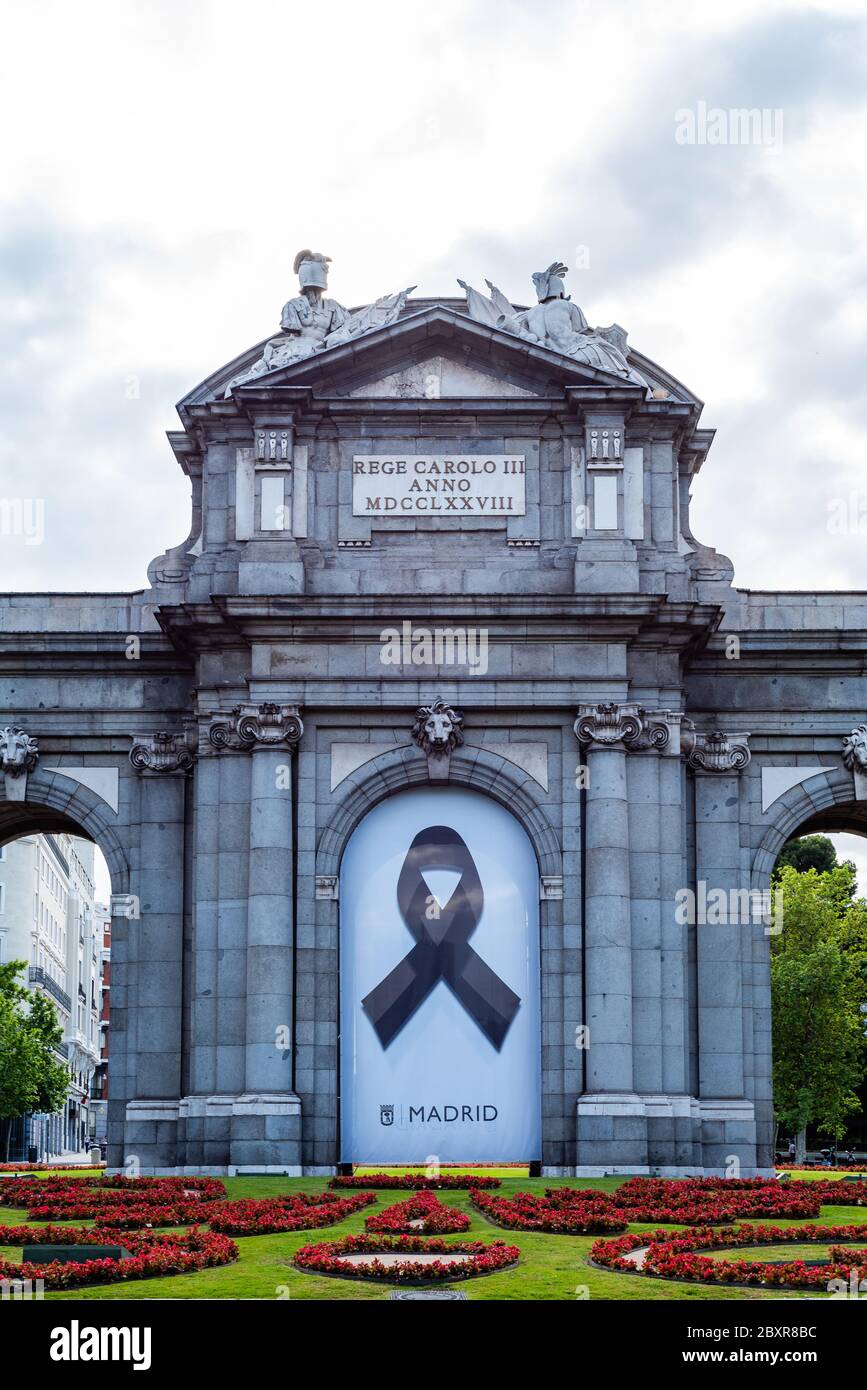 Madrid, Spain - June 7, 2020: Puerta de Alcala, or Alcala Gate. Banner with black ribbon as a symbol of mourning for those who have died during the co Stock Photo