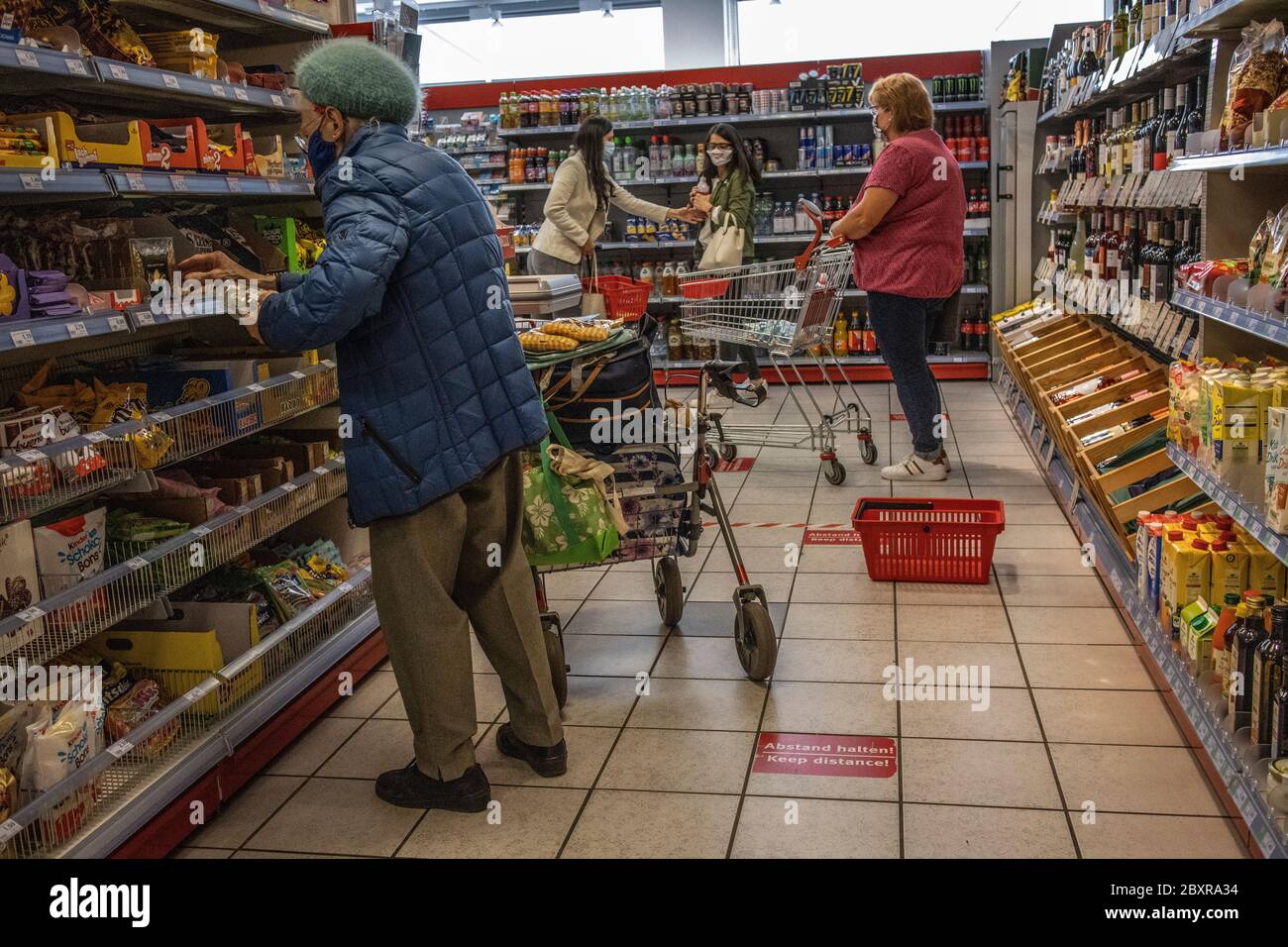 Shoppers in a local supermarket in Braunschweig wearing mandatory face masks after the coronavirus lockdown was lifted, north-central Germany, Europe Stock Photo