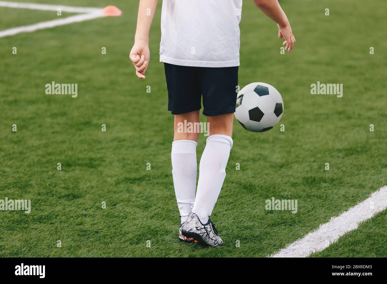 Soccer Player Juggling A Soccer Ball Young Boy Playing Football Sports Training Field In The Background Stock Photo Alamy