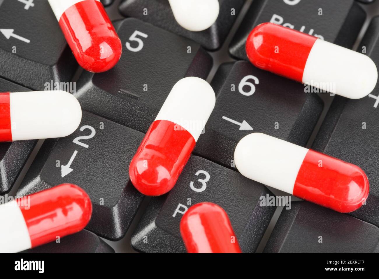 Pills on computer keyboard Stock Photo Alamy