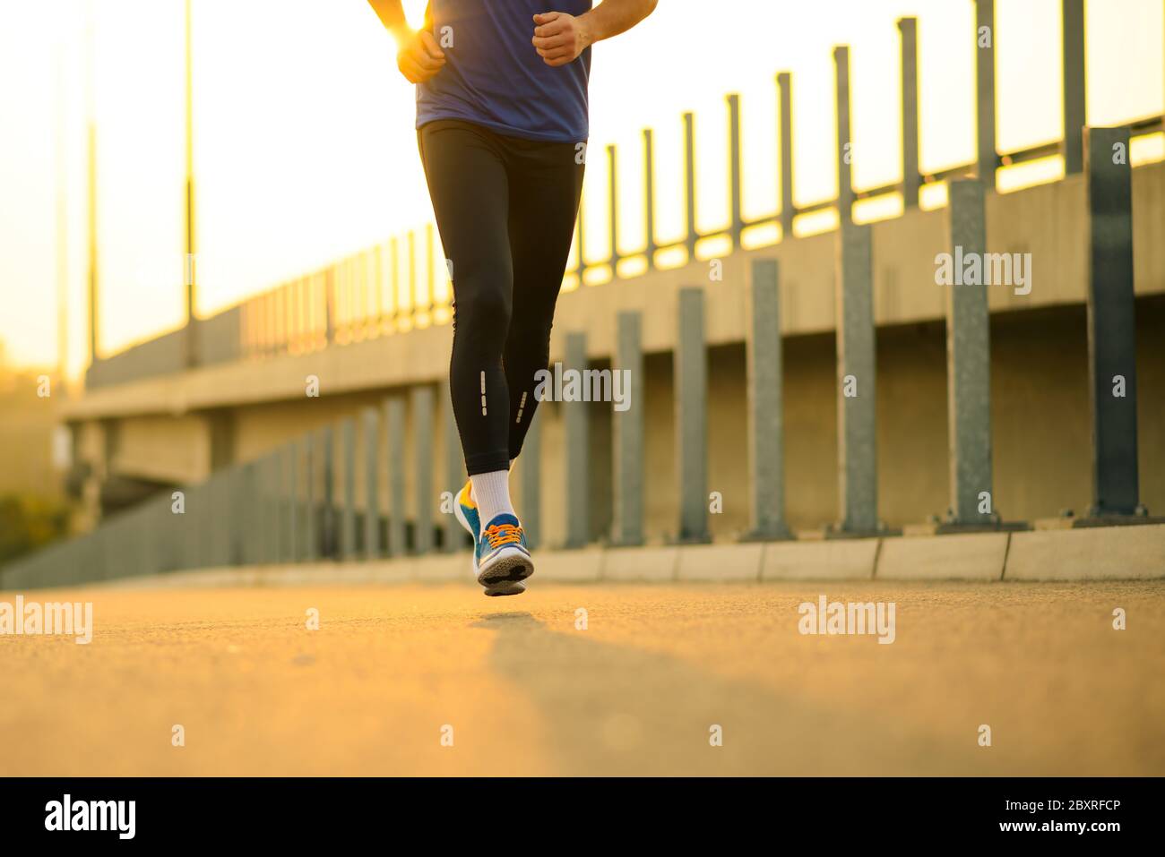 Closeup of Male Sports Mans Legs Running at Sunset. Healthy Lifestyle