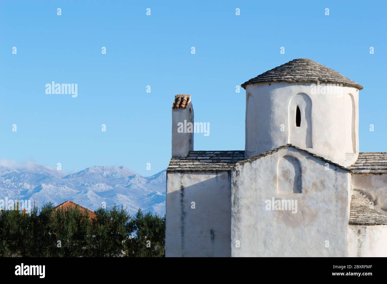 Church of Holy Cross in Nin, Croatia, and Velebit mountain in the background; preserved pre-romanesque architecture Stock Photo