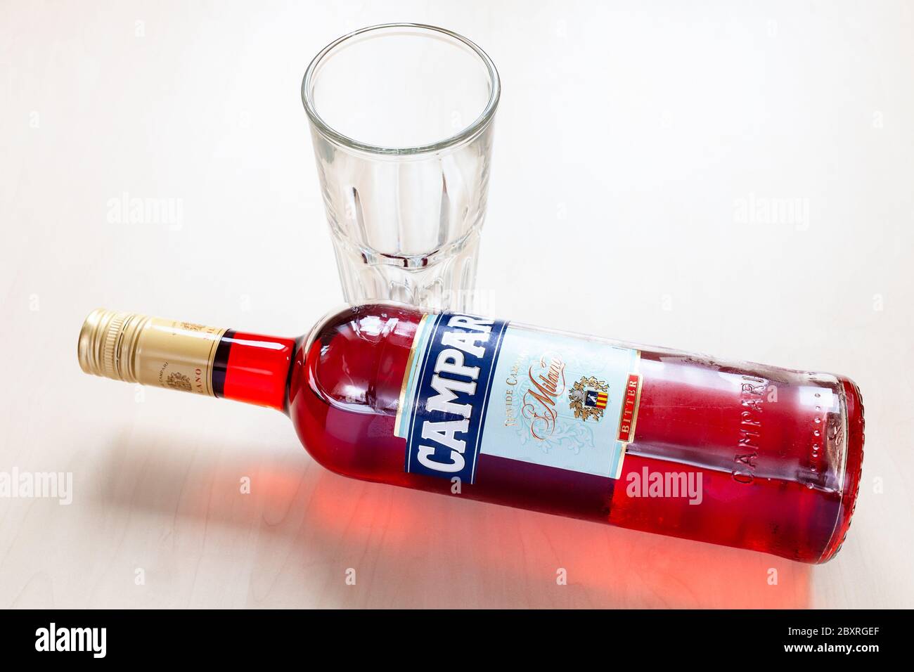 MOSCOW, RUSSIA - JUNE 4, 2020: lying bottle of Campari bitter and empty glass on table. Campari is italian alcoholic liqueur, trademark belong to Davi Stock Photo