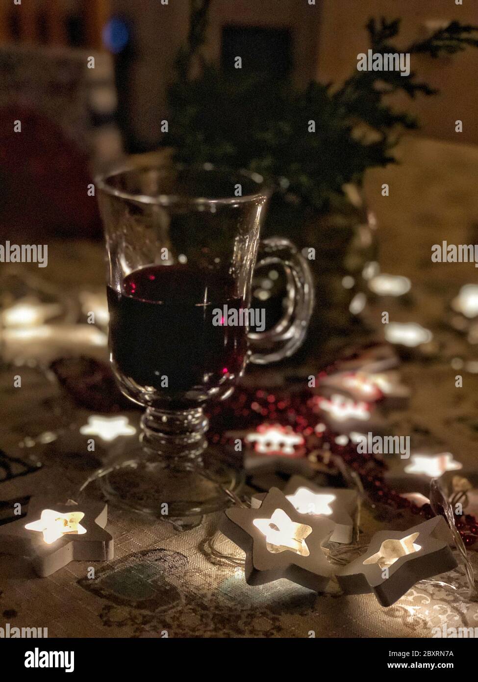 Winter glass of warm wine and christmas lights Stock Photo