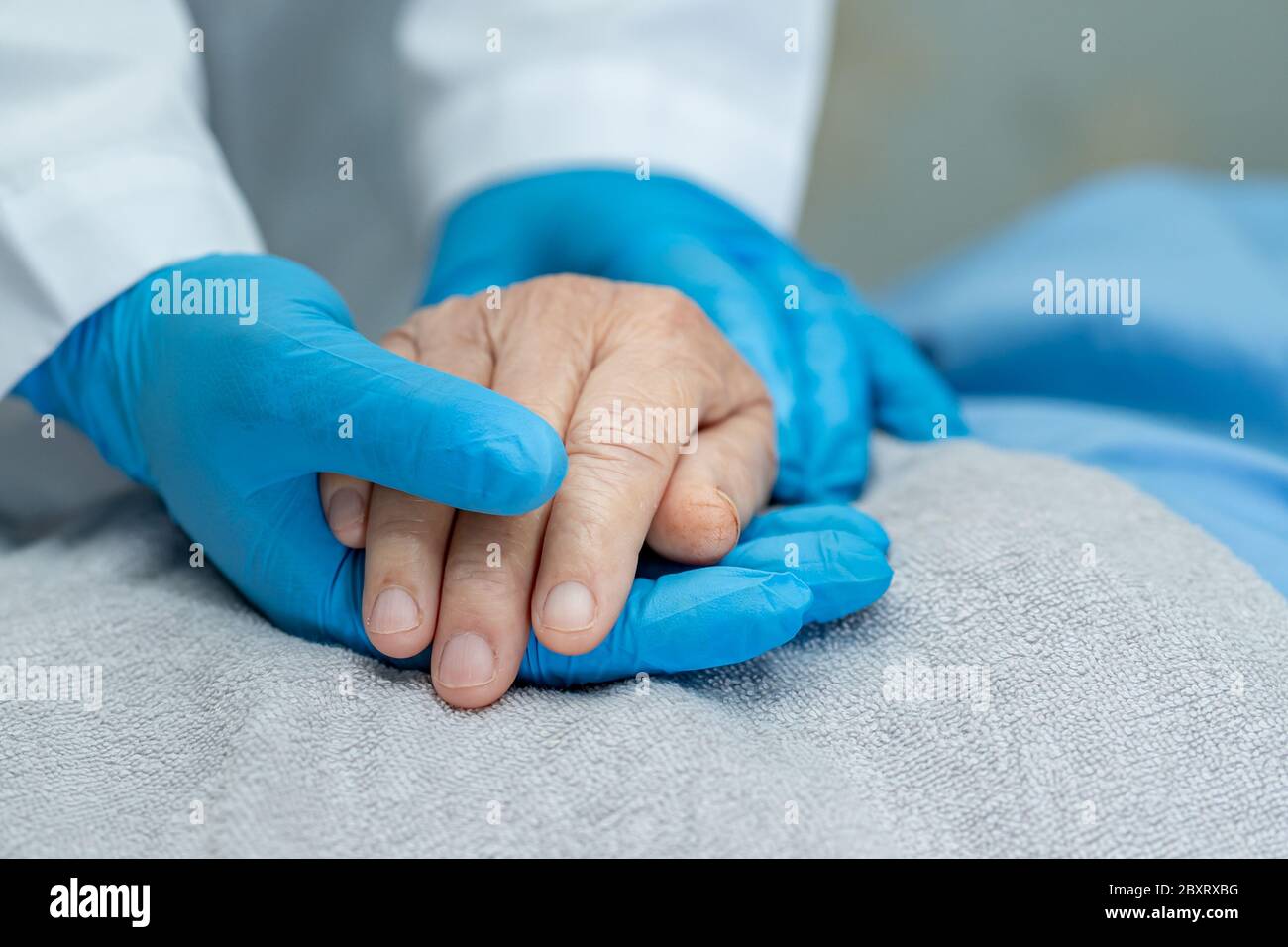 Doctor holding touching hands Asian senior or elderly old lady woman patient with love, care, helping, encourage and empathy at nursing hospital ward Stock Photo