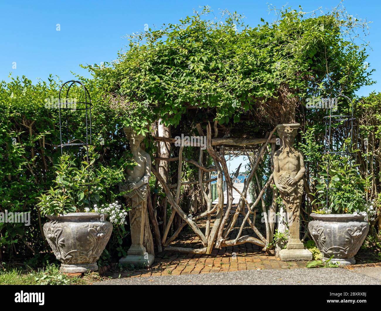 Elaborate entrance to a private dock featuring statues, urns and a hand made gate, Dering Harbor, NY Stock Photo