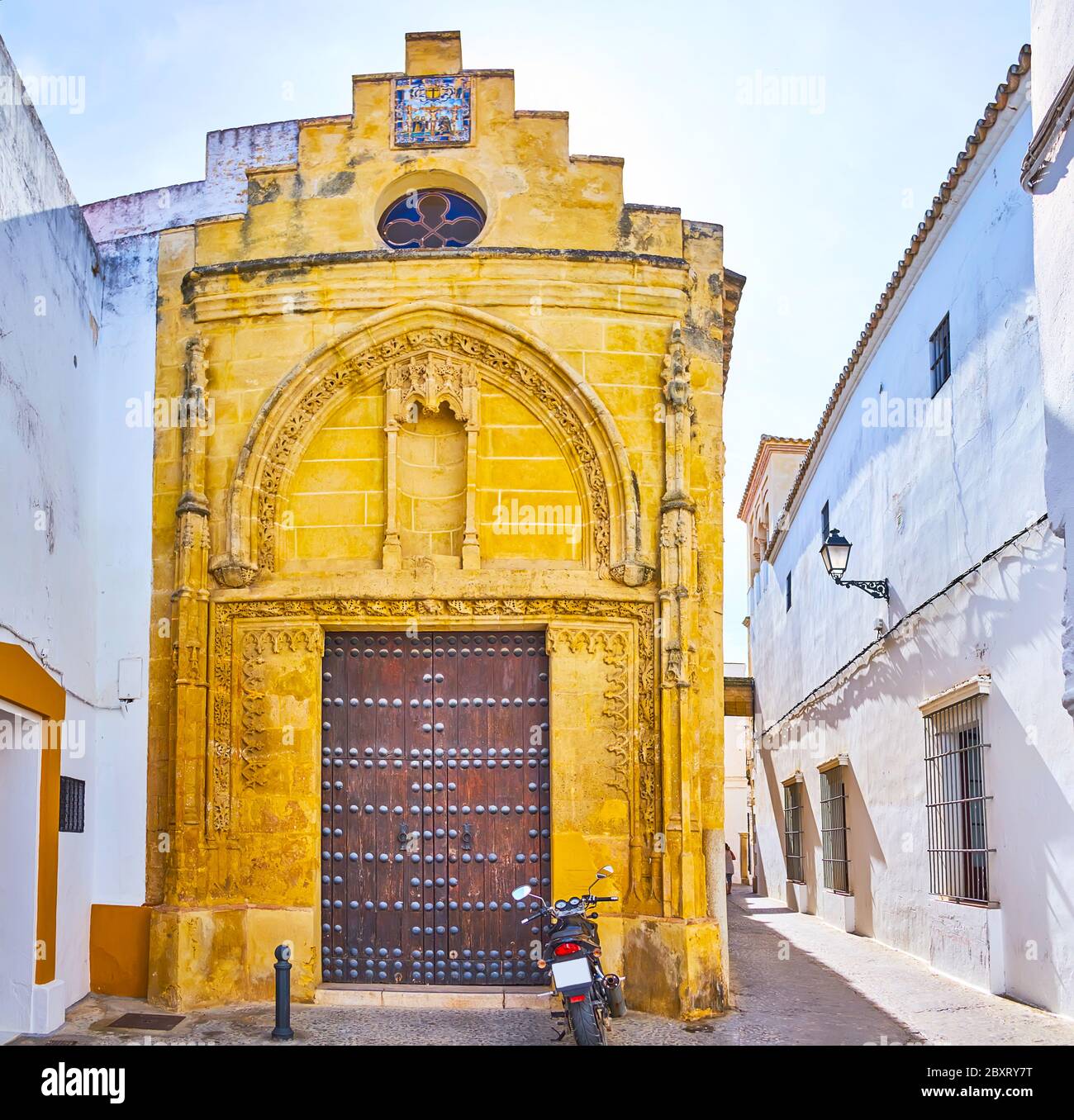 The facade of medieval Gothic Chapel of Mercy, hidden in narrow Calle Nunez del Prado street of Arcos, Spain Stock Photo