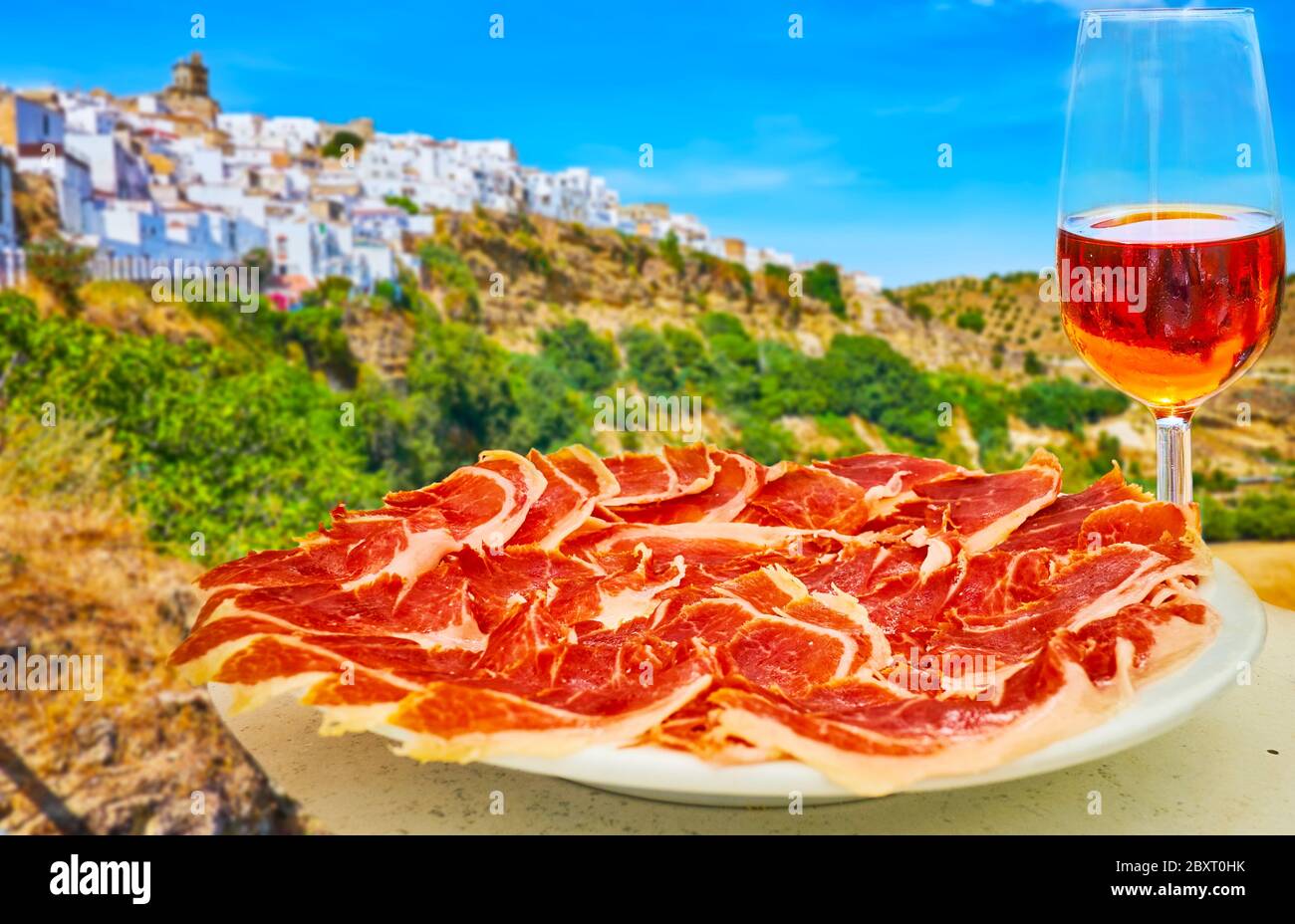 Spanish Jamon Serrano on wooden tabla jamonera with knife, apple, glass and  bottle of red wine. Home cooking, food photo concept Stock Photo - Alamy
