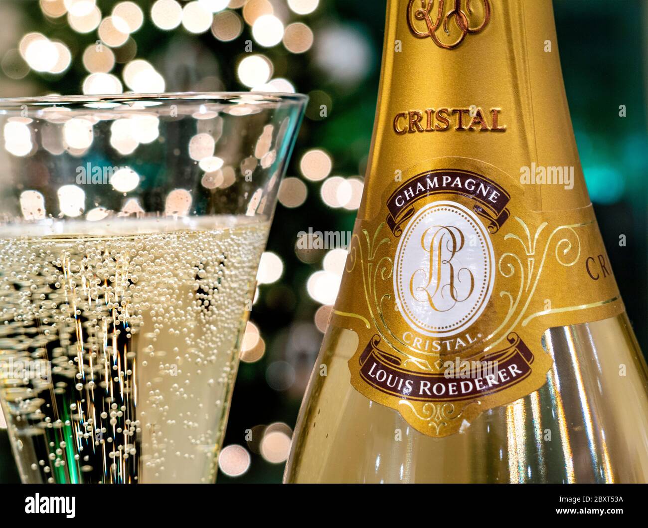 CRISTAL CHAMPAGNE Bottle and freshly poured glass of Louis Roederer Cristal luxury champagne with sparkling party celebration  lights in background Stock Photo