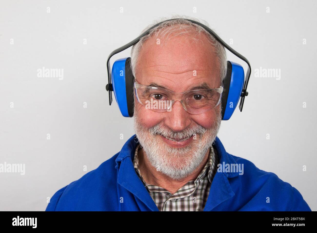 Old, experienced craftsman have a good laugh because they always play it safe and wear hearing protection and safety glasses. Stock Photo