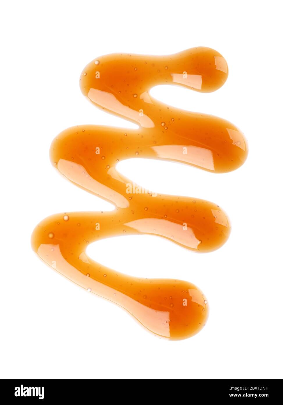 Caramel syrup drizzle isolated on white background. Splashes of sweet