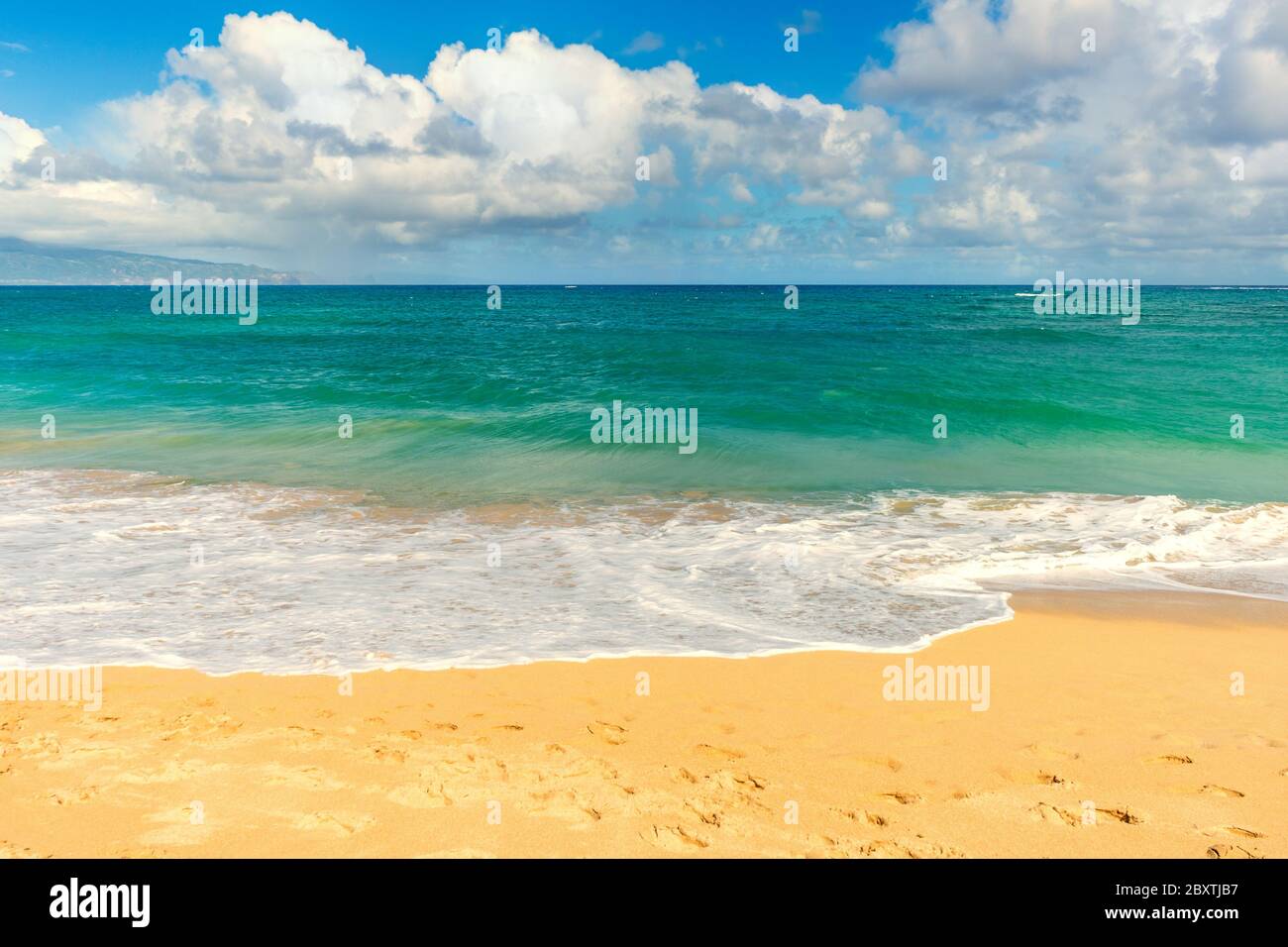 A sandy beach with clouds on the Hawaiian Island of Maui. Stock Photo