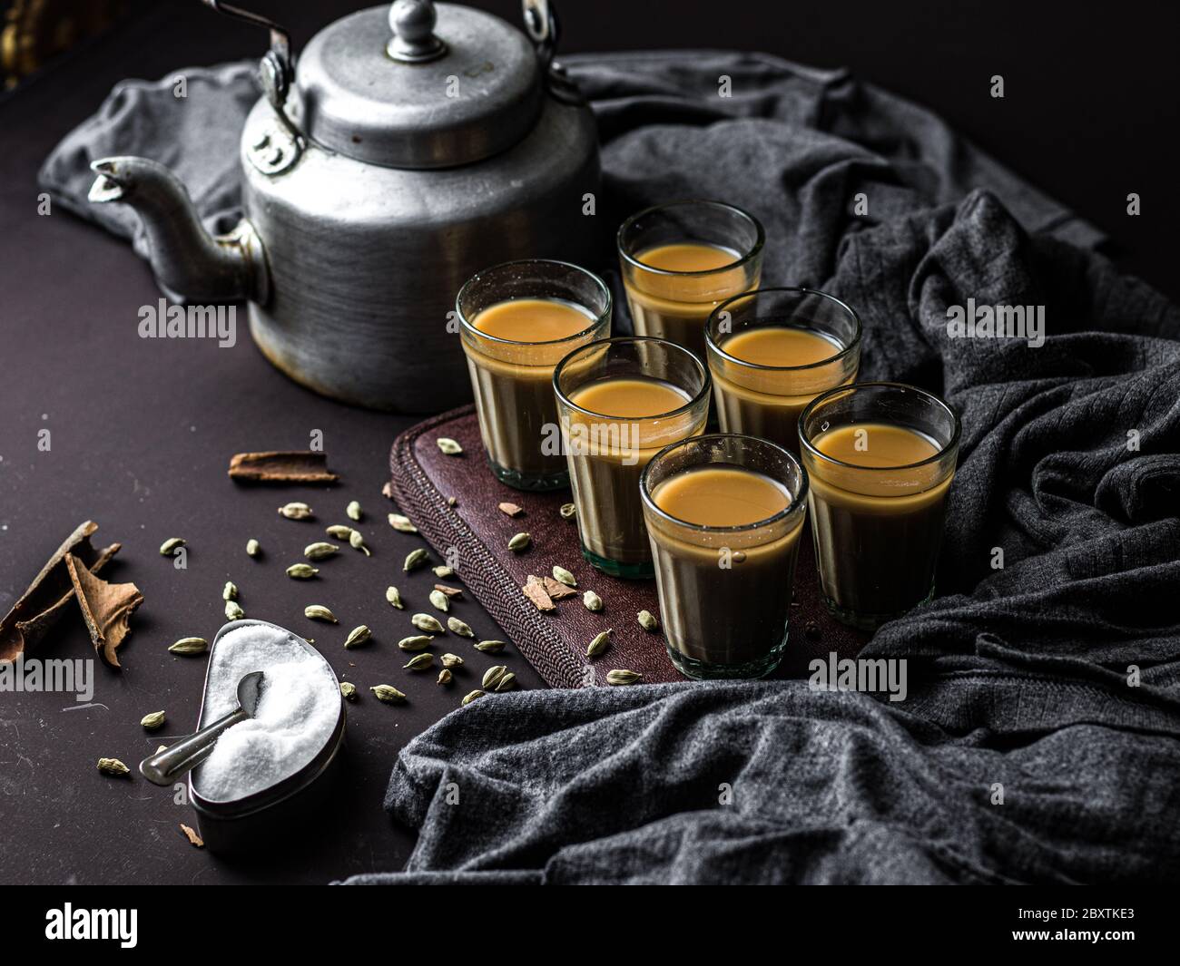 https://c8.alamy.com/comp/2BXTKE3/indian-chai-in-glass-cups-with-metal-kettle-and-other-masalas-to-make-the-tea-2BXTKE3.jpg