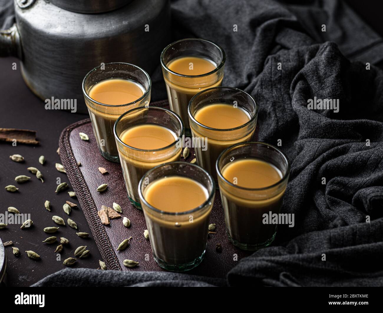https://c8.alamy.com/comp/2BXTKME/indian-chai-in-glass-cups-with-metal-kettle-and-other-masalas-to-make-the-tea-2BXTKME.jpg