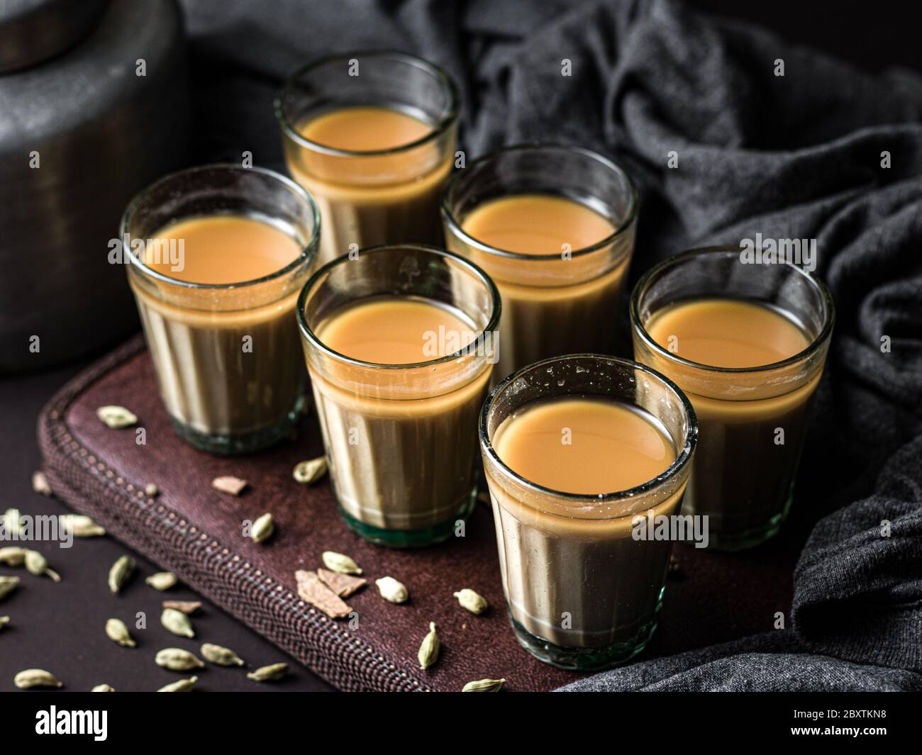 Indian chai in glass cups with metal kettle and other masalas to make