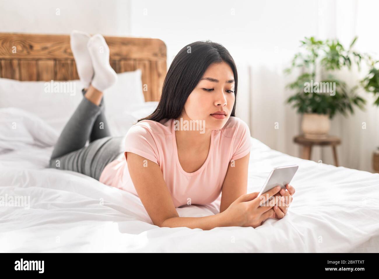 Serious girl lying on bed hi-res stock photography and images - Alamy