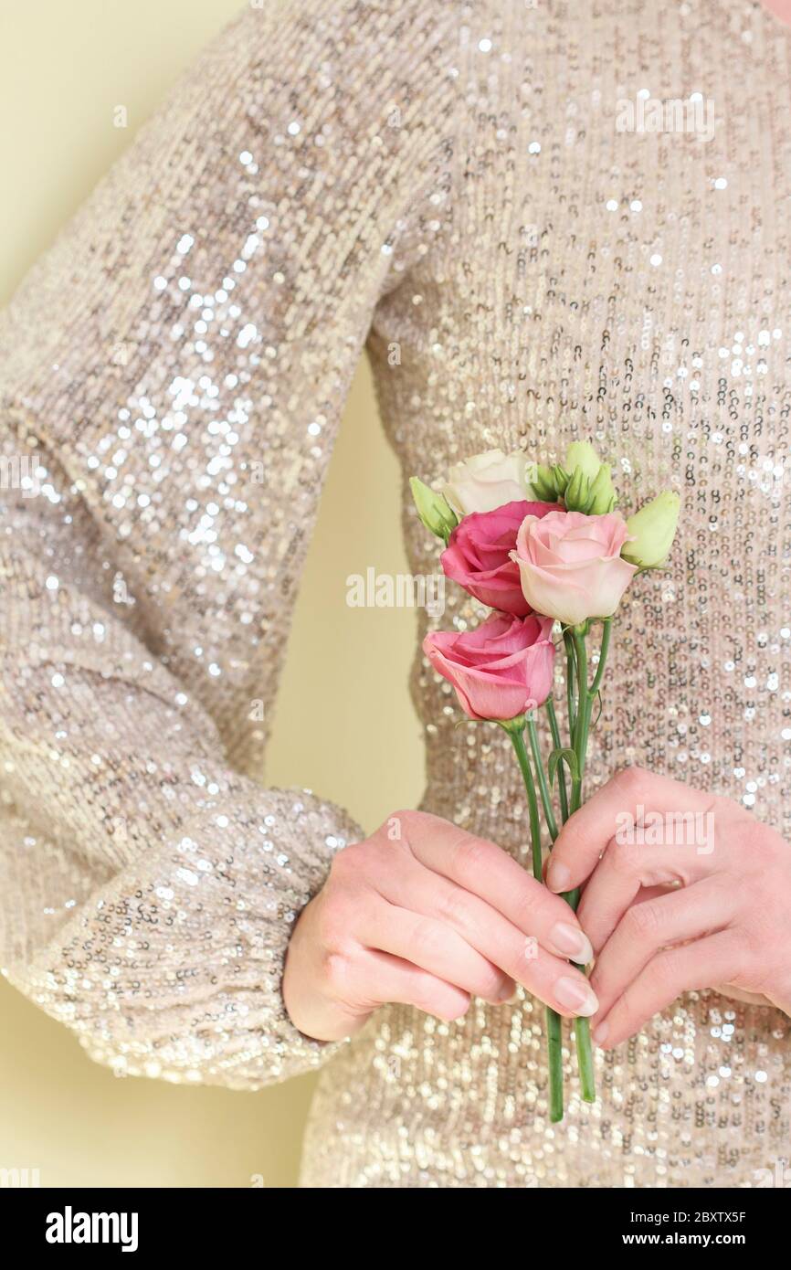 Young woman is holding a bouquet of eustoma flowers. Beautiful hands and long natural nails. Stock Photo