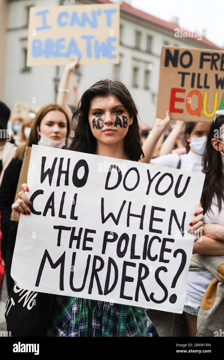 Cracow, Lesser Poland, Poland. 7th June, 2020. A young female protester with the abbreviation 'ACAB' painted on her face holds a placard with a slogan 'Who do you call when the police murders?' during the Black Lives Matter protest.Hundreds of young people took part in 'Black Lives Matter' protest in Cracow, the biggest city in southern Poland. They paid tribute to George Floyd and expressed their disapproval of police brutality and racism. Credit: Filip Radwanski/SOPA Images/ZUMA Wire/Alamy Live News Stock Photo