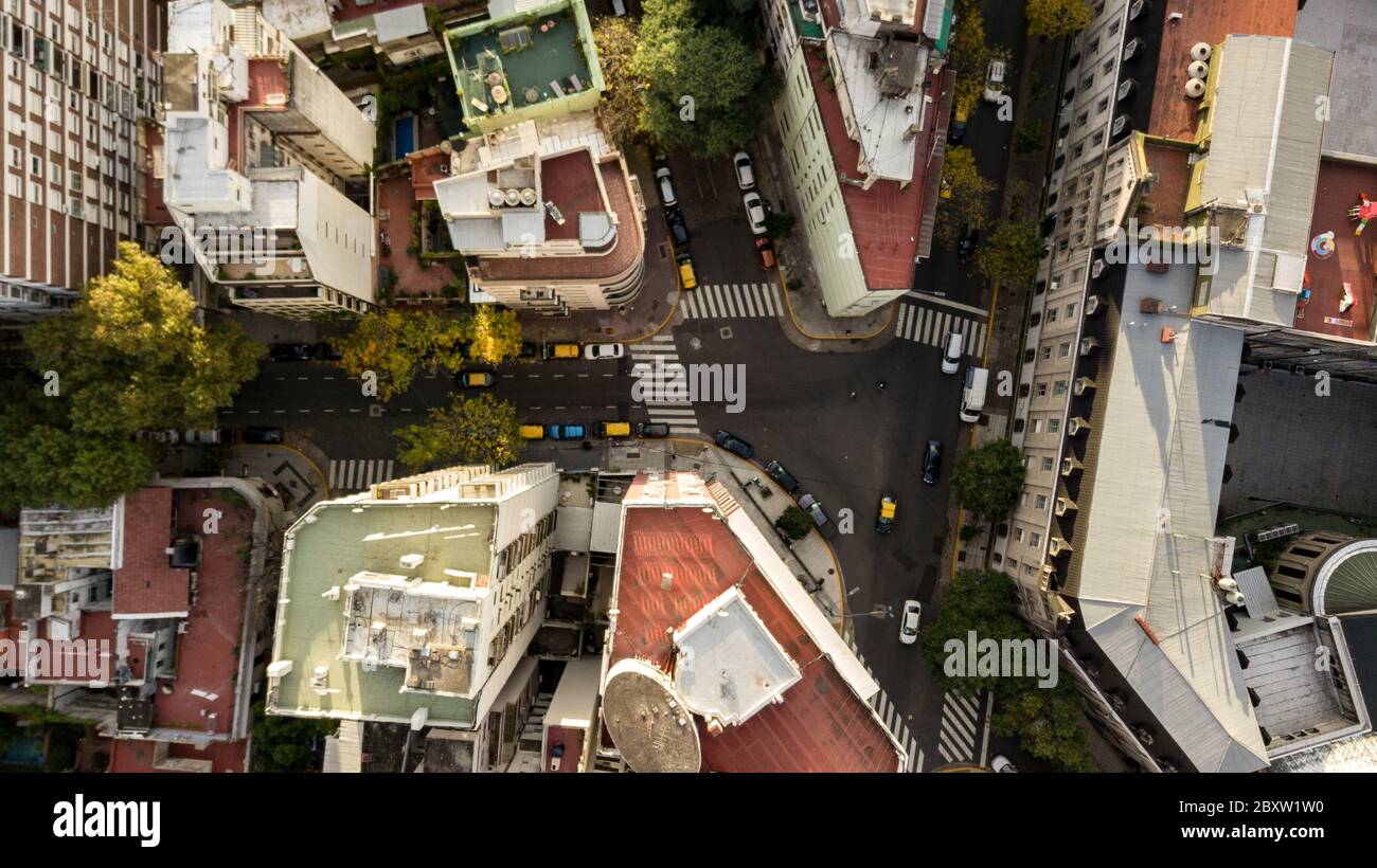 Aerial view of the residential buildings with the main street, autumn trees, colorful cars passing by, different rooftops. Stock Photo
