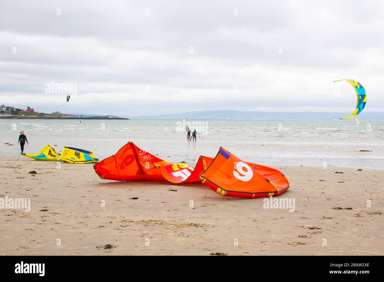 6 June 2020 Kite surfers and wind surfers enjoy the wind, waves and surf at Ballyholme Beach in Bangor Northern Ireland on a dull afternoon during the Stock Photo