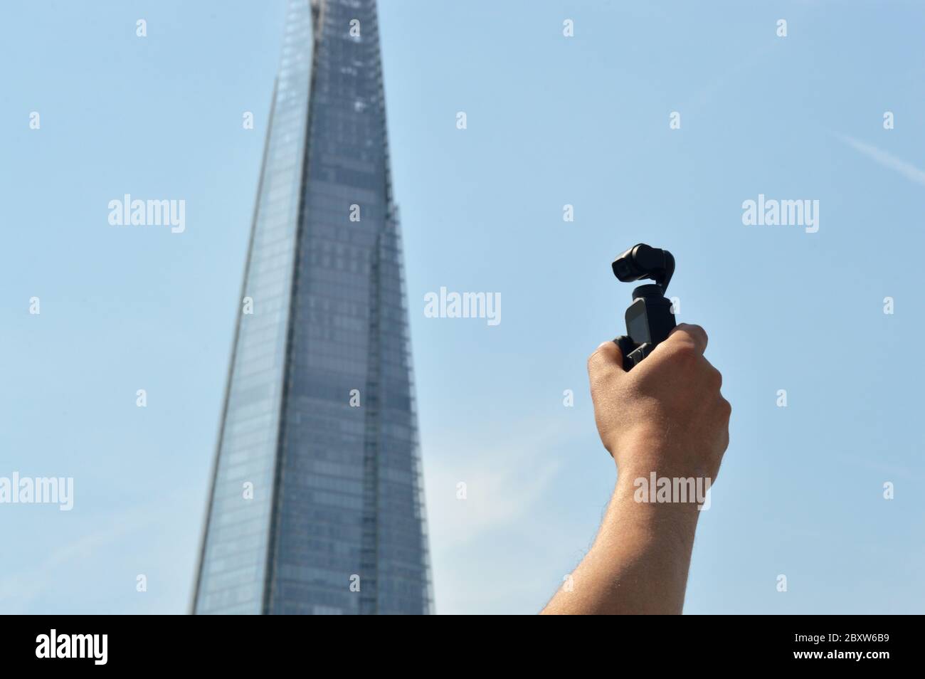 London, UK - August 2019: Male hand holding a DJI Osmo Pocket gimbal camera in front of famous British landmark Stock Photo