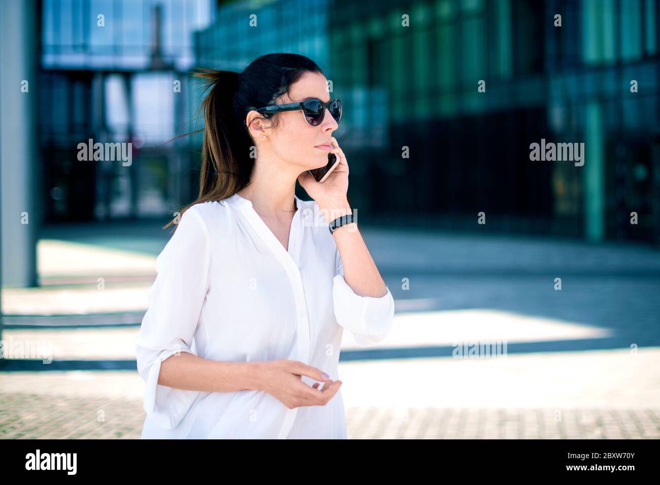 Closeup shot of attractive woman making a phone call while walking on