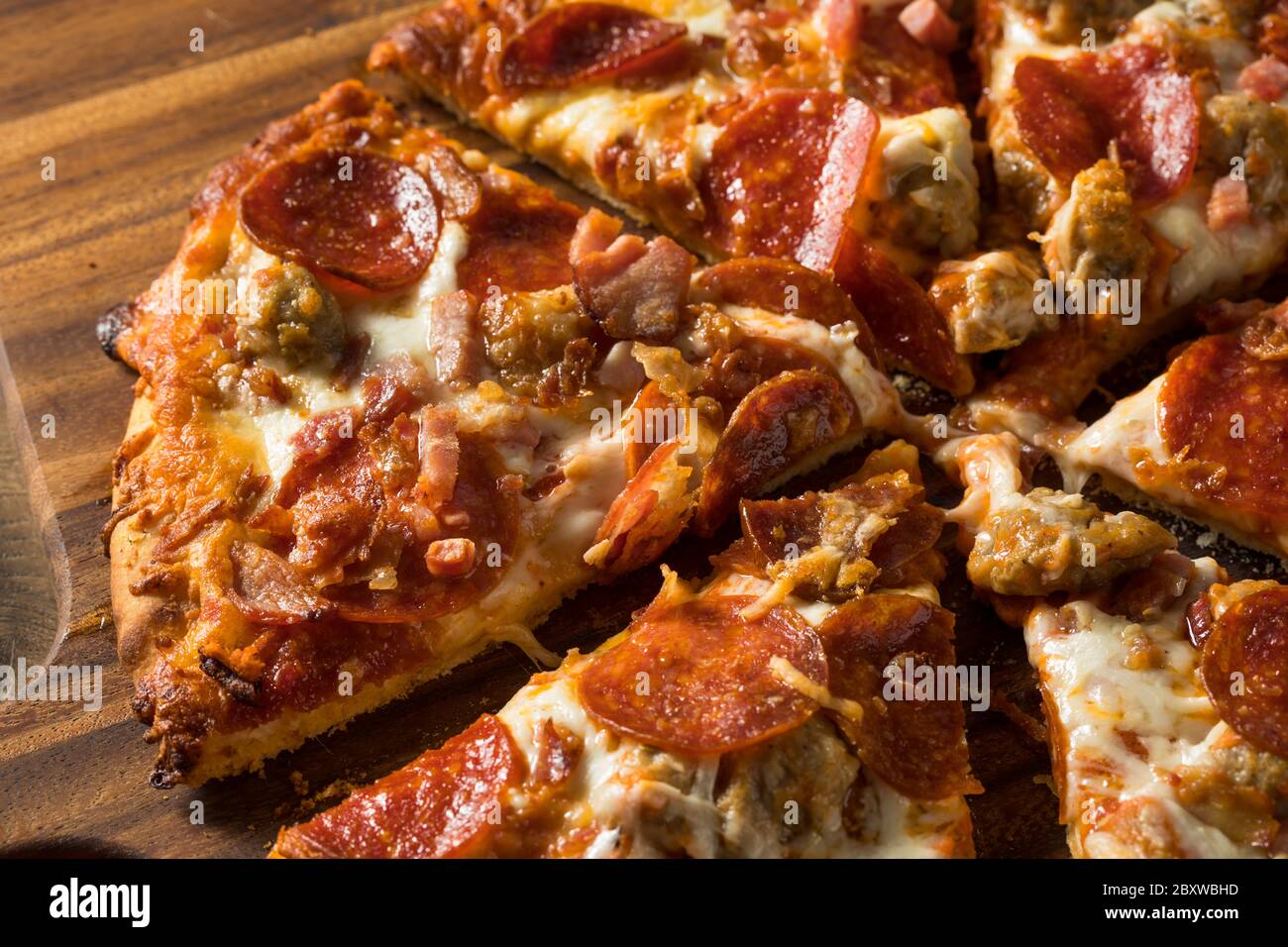 Savory Homemade Meat Lovers Pizza with Pepperoni and Bacon Stock Photo
