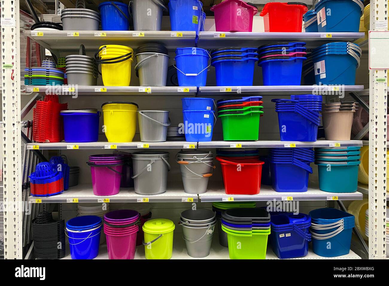 Shelves in the store with plastic dishes. Inexpensive alternative to dishes made from natural materials. Colorful of plastic baskets, bowls and basins Stock Photo