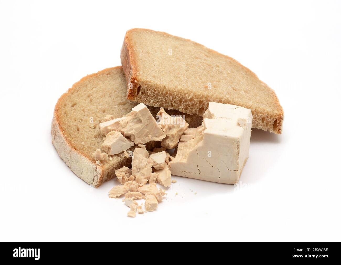 Fresh yeast block crumbled on two slices of bread over white background. Stock Photo