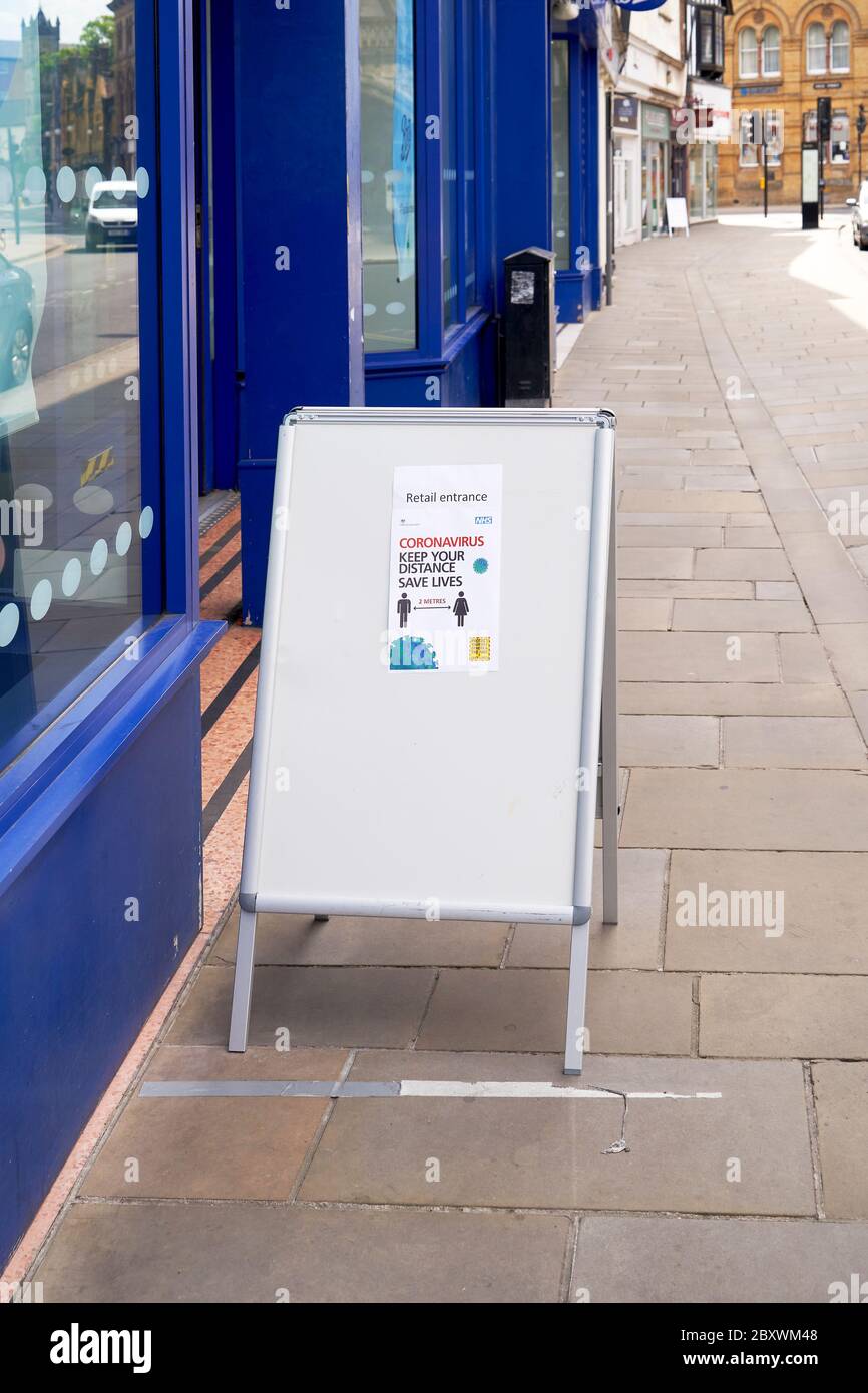 Social distancing poster at the entrance to a retail shop during Coronavirus emergency Stock Photo