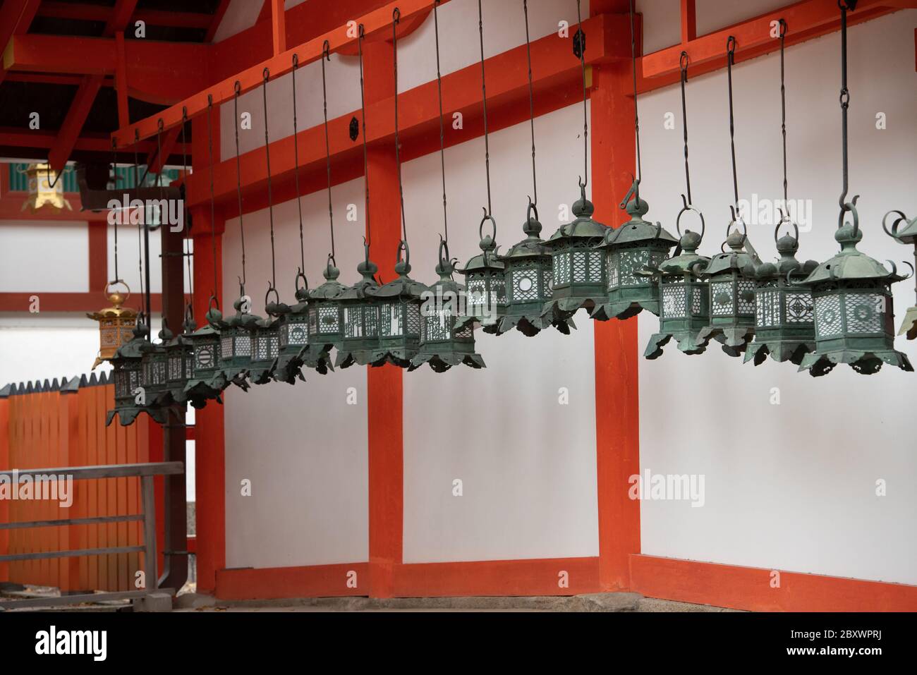 Handmade metal lanterns hanging from the roof of one of the buildings at unesco world heritage site of Kasuga Taisha shrine in Nara, Japan. Stock Photo