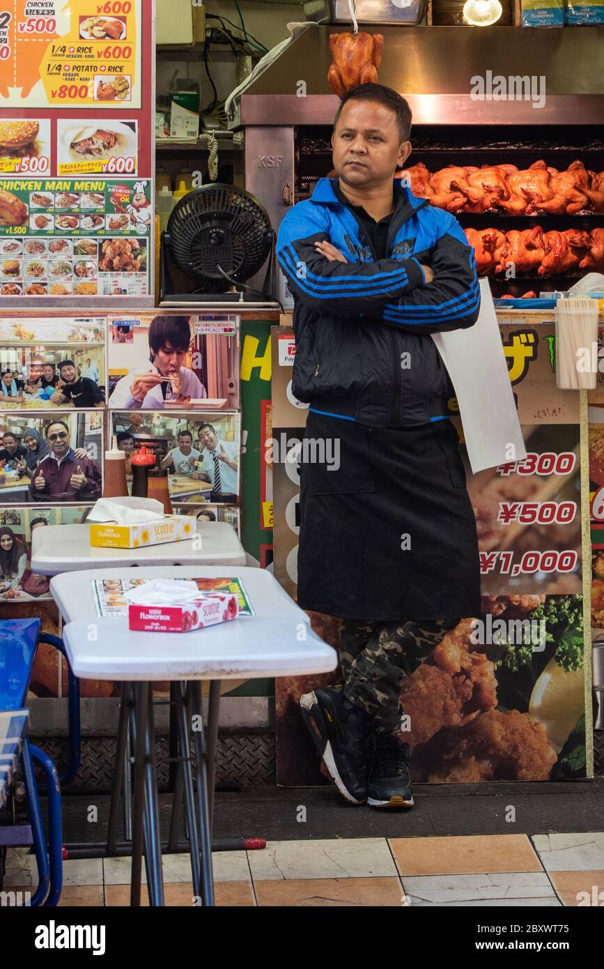 A fast food stall owner in front of his stall at Ameyoko market in Tokyo, Japan Stock Photo