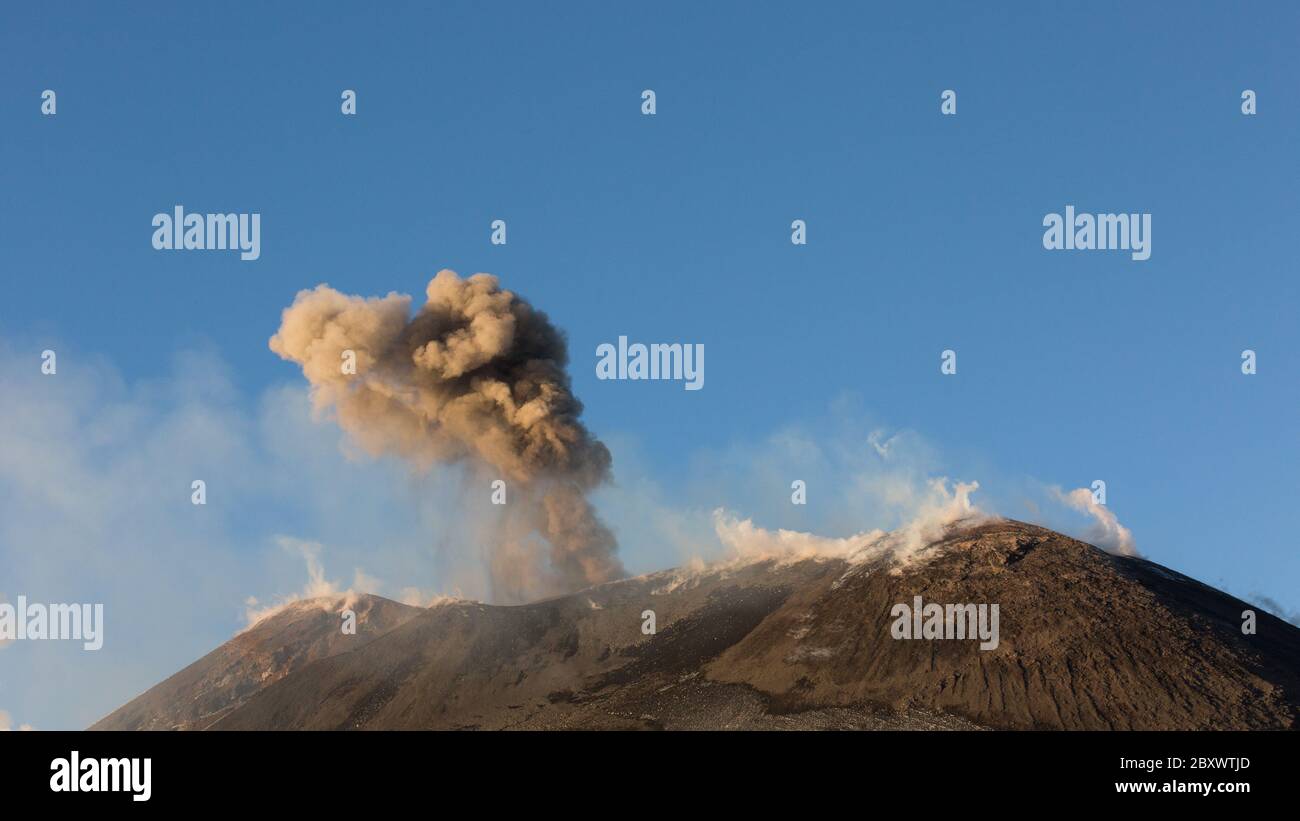 Etna Volcano with smoke and ash during eruption from top crater at sunset Stock Photo