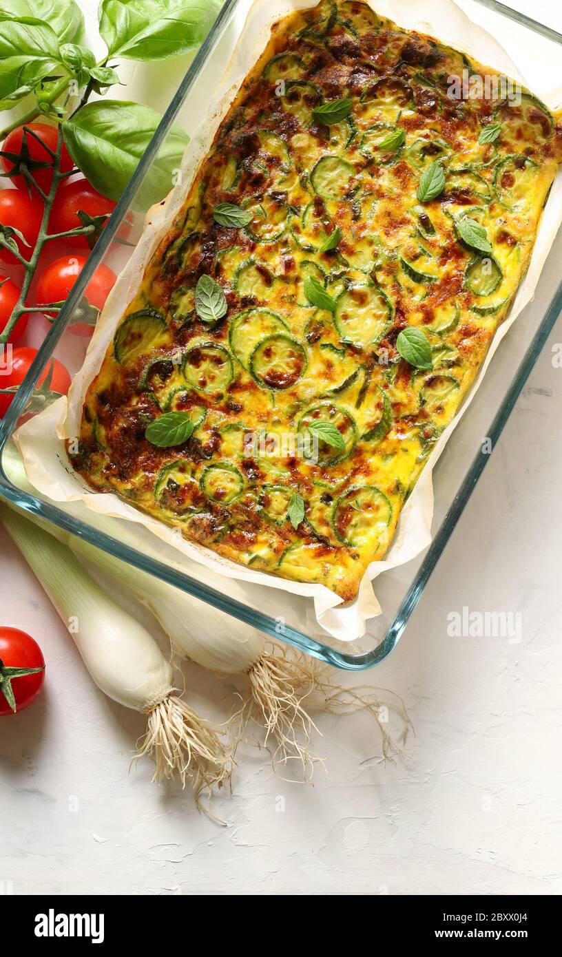 Food concept. Oven baked omelette with zucchini, leeks and cheese in a