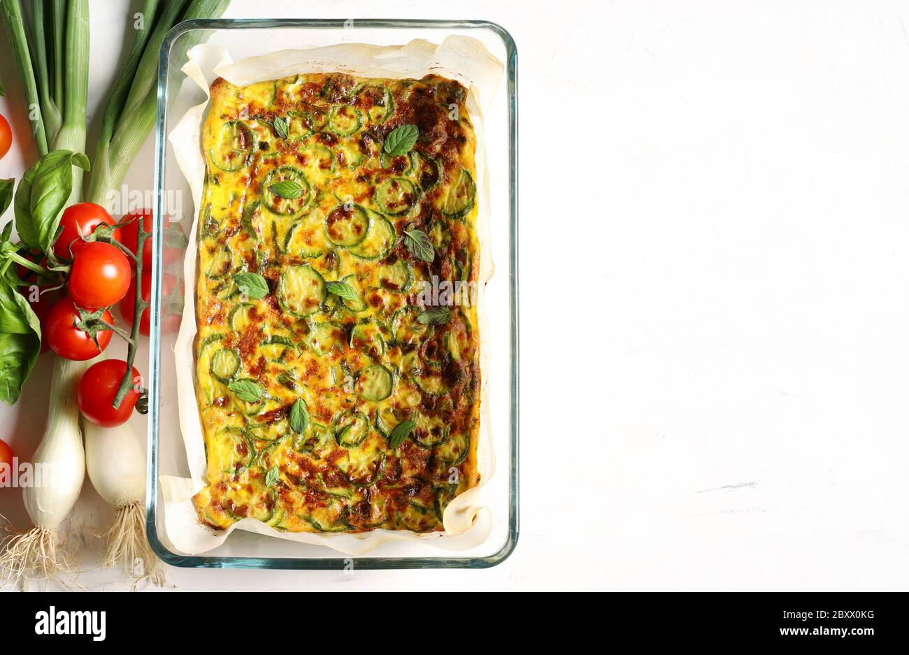 Food concept. Oven baked omelette with zucchini, leeks and cheese in a