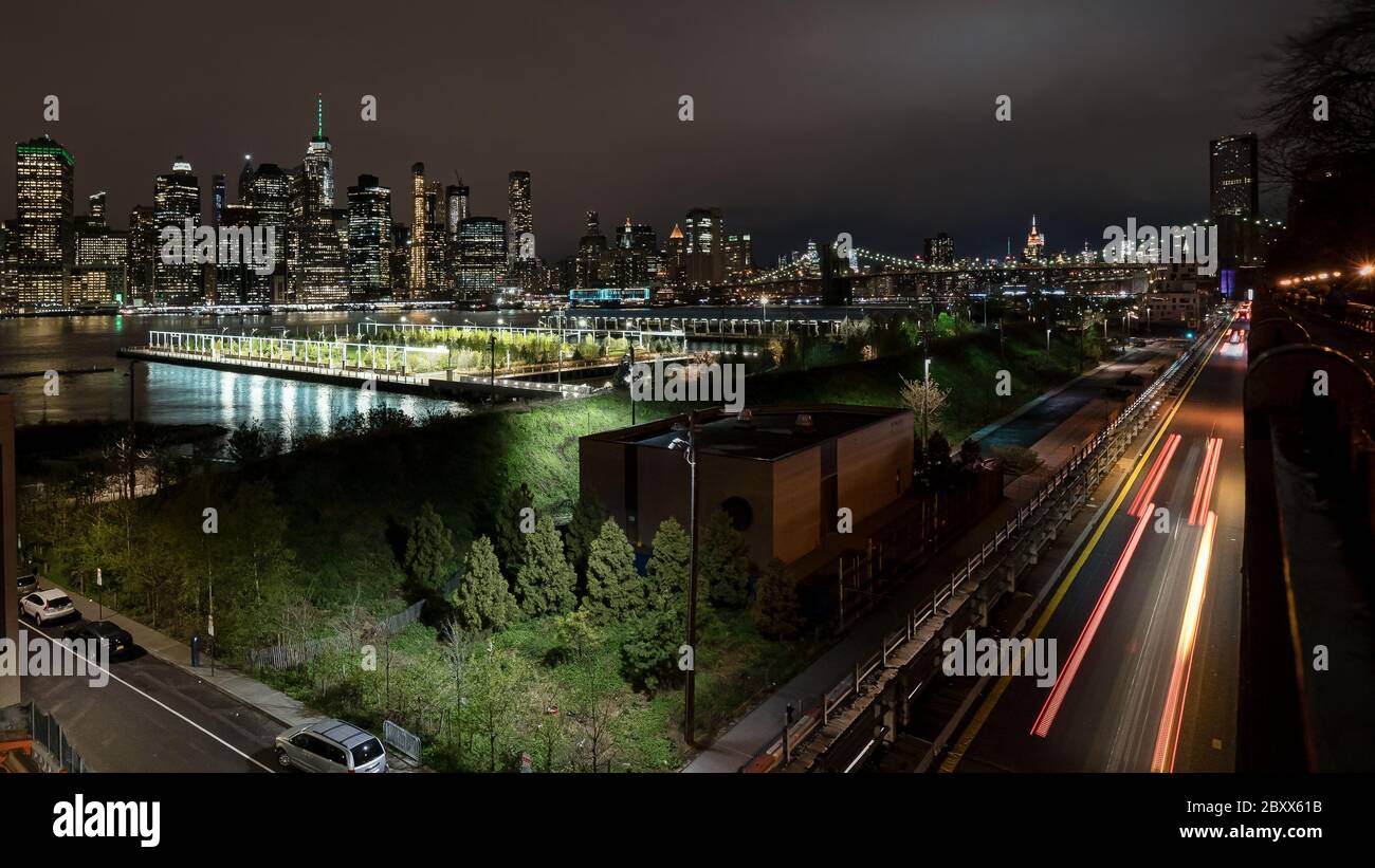 Night time light trails looking from the Brooklyn Heights promenade towards the Manhattan skyline, NYC Stock Photo