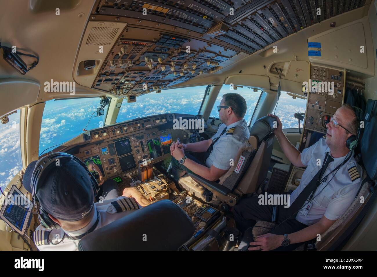 Cockpit view in Boeing 757-200 with pilot and co-pilot and navigator Stock Photo