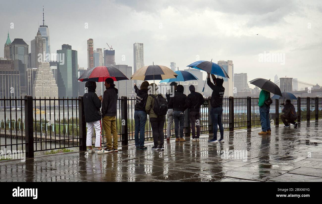Sightseers gaze at the Manhattan skyline from the Brooklyn promenade in New York City Stock Photo
