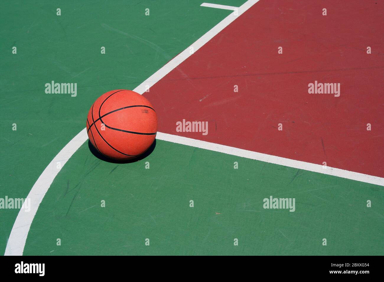 A Basketball at free throw line on red and green court Stock Photo