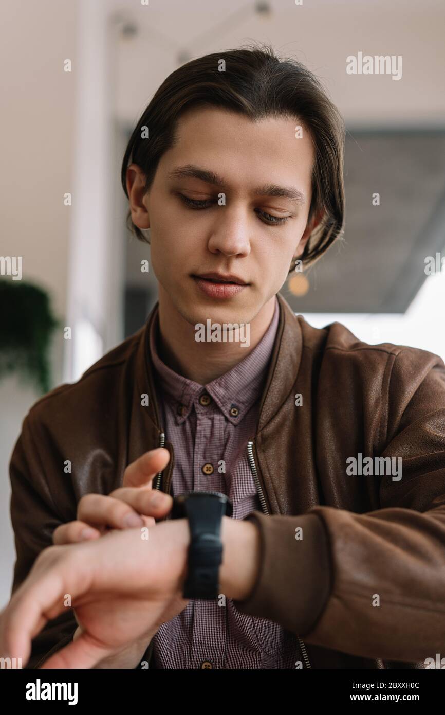 Young positive man using smart watch application, touching digital screen, receiving email. Wireless technology, innovation concept Stock Photo