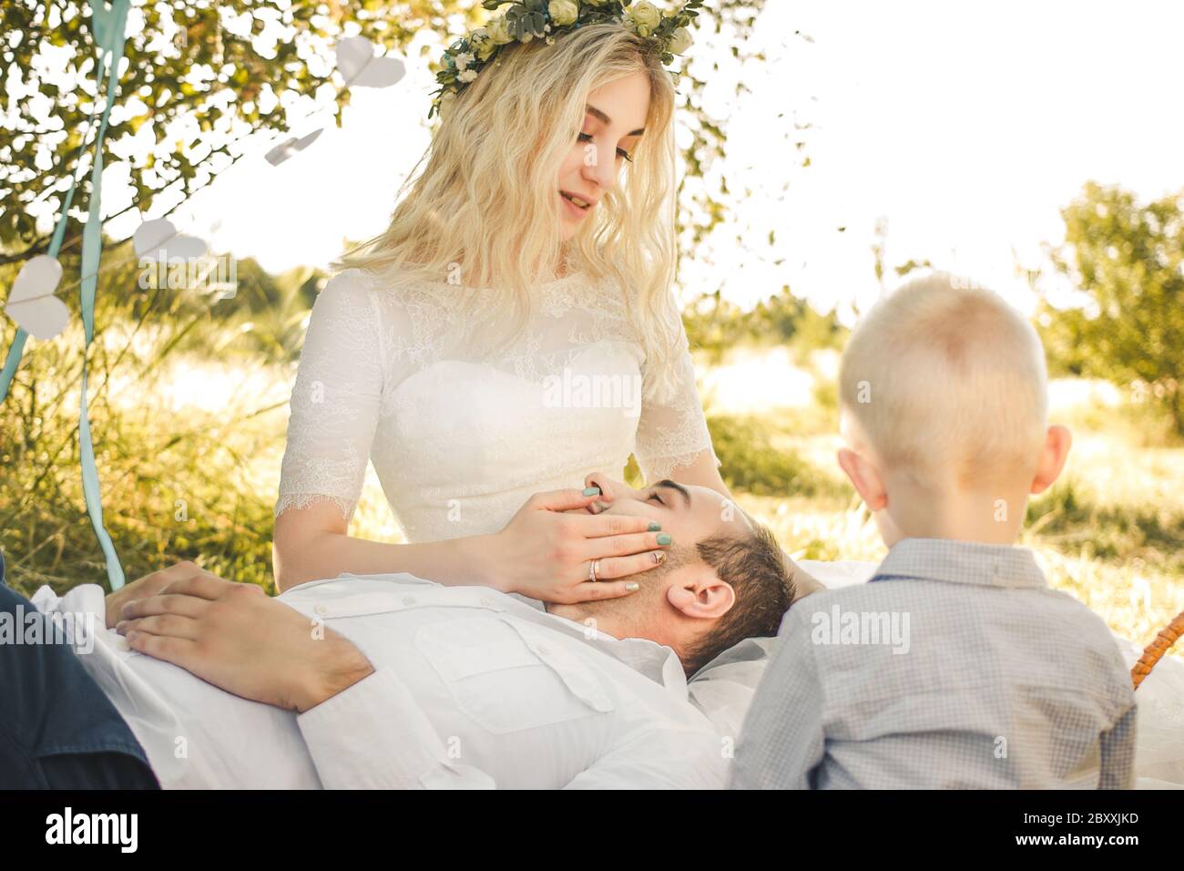 Little Blond Haired Toddler Boy Groom Lying On Knees Of Bride In Wedding Dress Outdoor Wedding Scene In Sunny Summer Dress Stock Photo Alamy