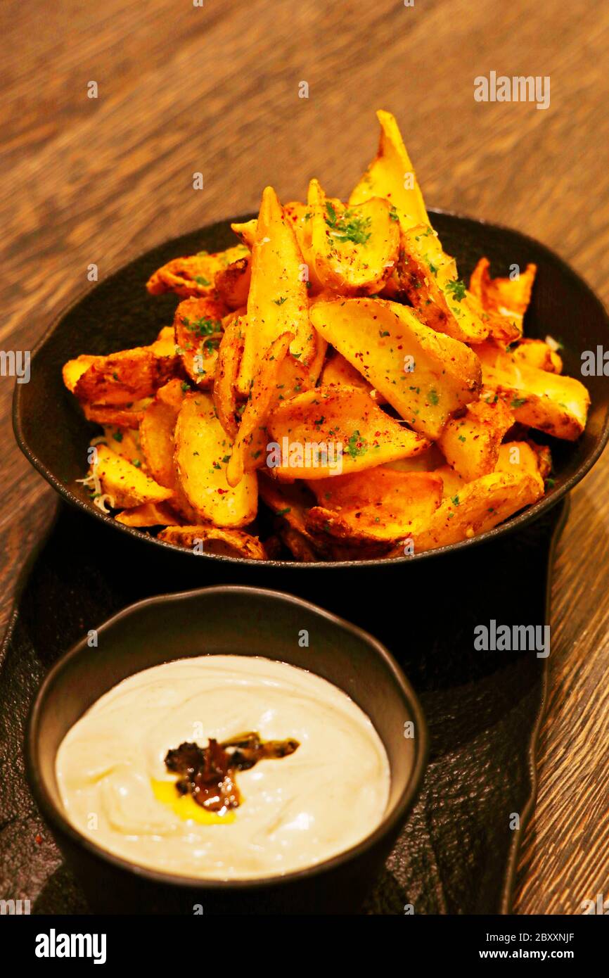 crispy fried potato chips or wedges with truffle cream dip Stock Photo