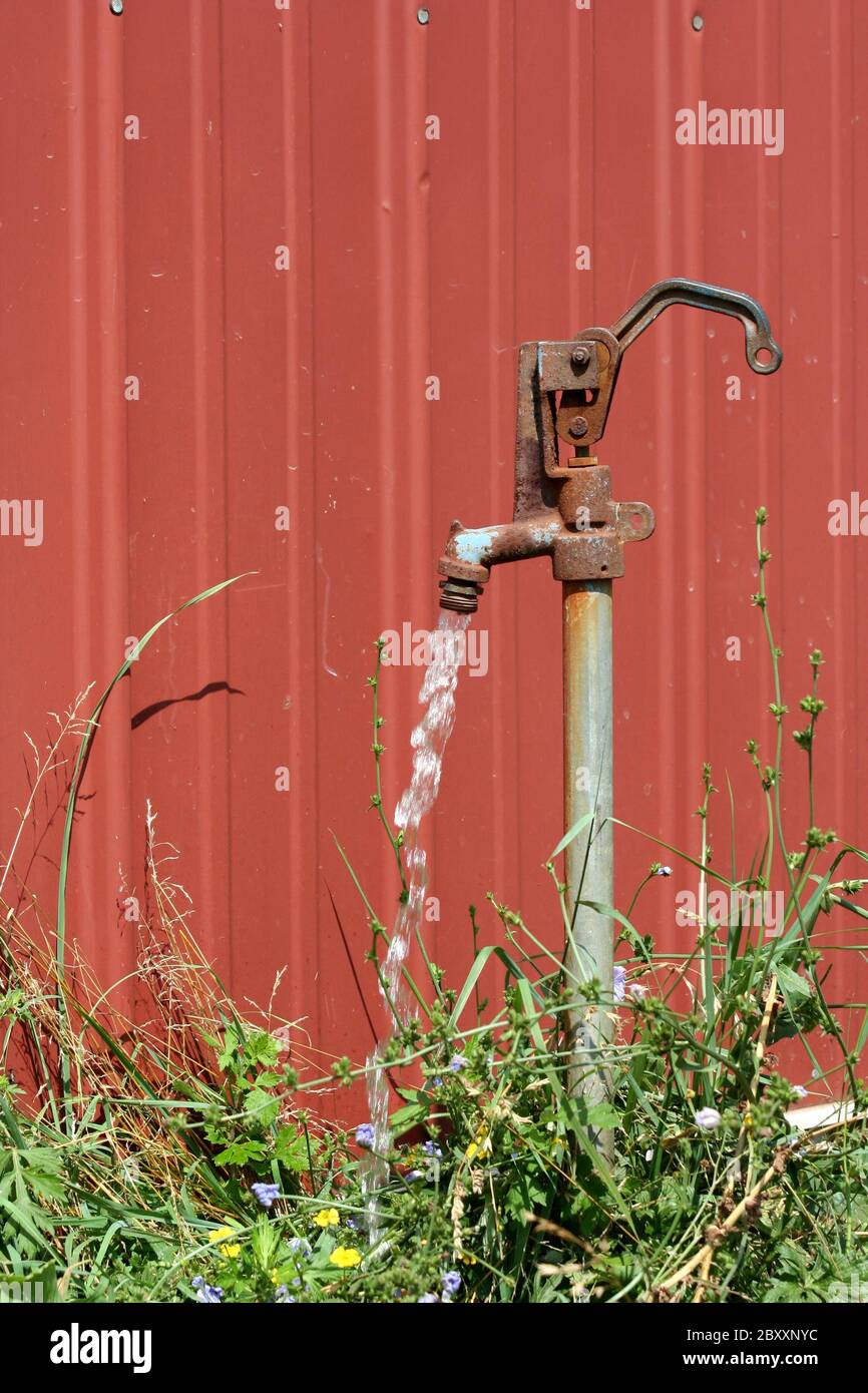 A Old water spigot with running water Stock Photo