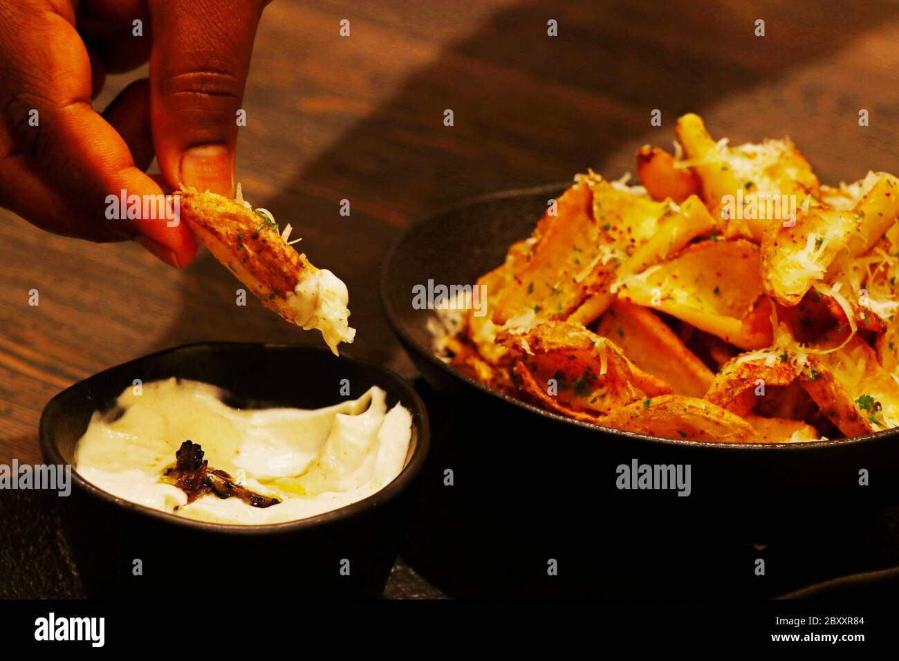 crispy fried potato chips or wedges with truffle cream dip Stock Photo