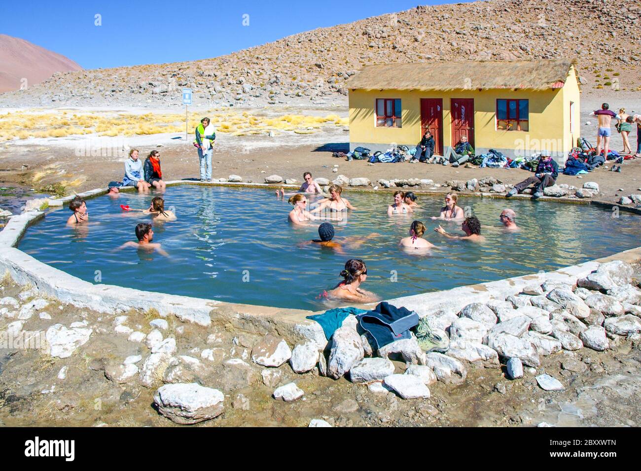 Hot springs Aguas Termales de Polques with pool of natural thermal water scenically set in impressive rocky Andean landscape, clouds of steam to flush with water of a lagoon in Bolivia, near the Chile Stock Photo