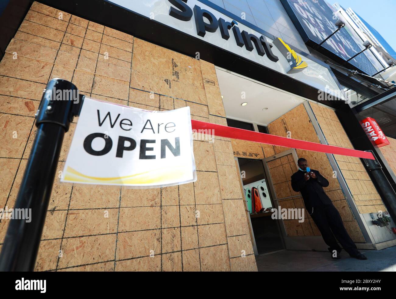 New York, USA. 8th June, 2020. A worker waits for customers outside a Sprint store in Manhattan of New York, the United States, June 8, 2020. After nearly three months of lockdown, New York City entered the first phase of reopening on Monday, 100 days since the city reported its first COVID-19 case. Credit: Wang Ying/Xinhua/Alamy Live News Stock Photo